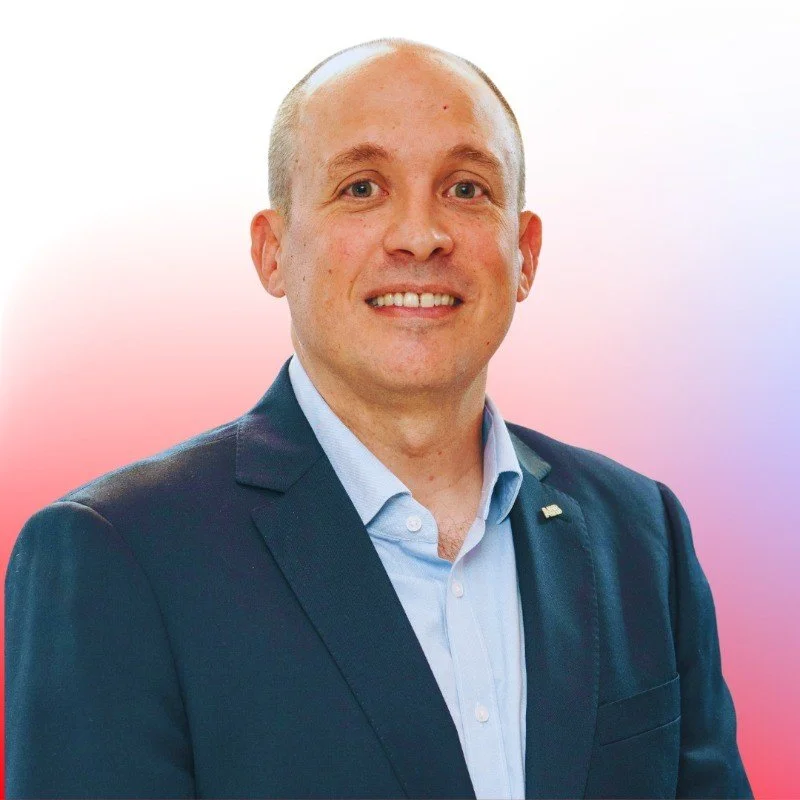 Portrait of a person in a suit with a gradient background.