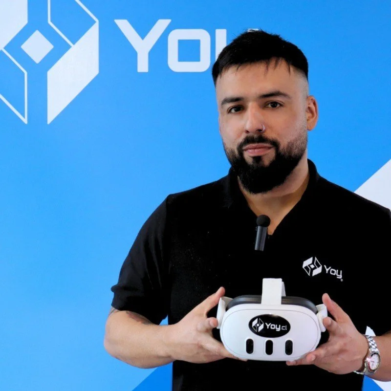 Diego Opazo holding a VR headset with the Yoy logo in front of a blue background.