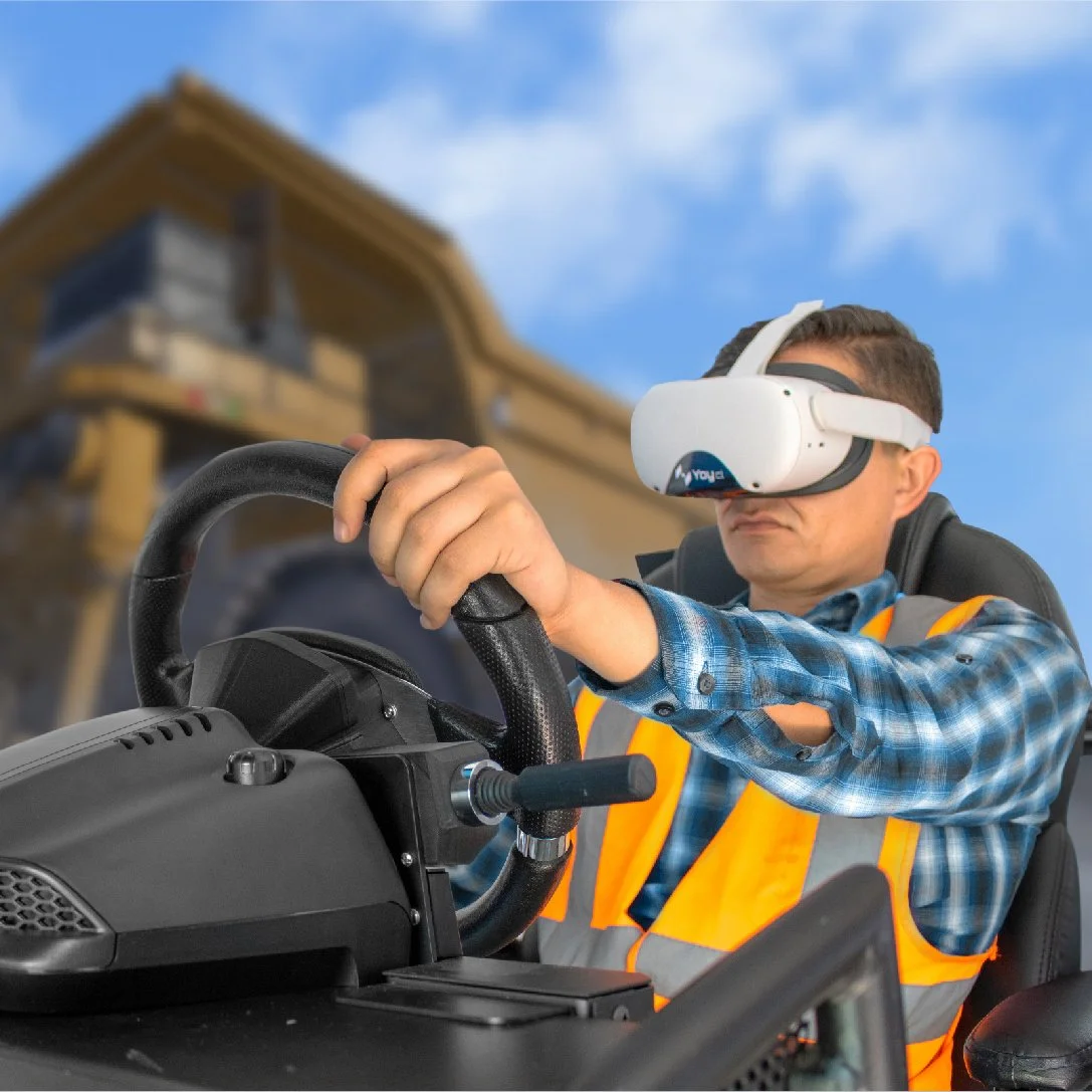 Person wearing a VR headset and high-visibility vest, holding a steering wheel, simulating vehicle operation in a virtual setting.