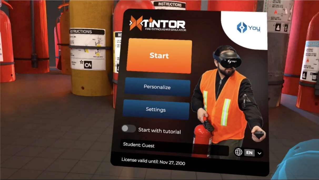 Interfaz del simulador de extintores en realidad virtual con botón de inicio, ajustes y una persona con visor VR y chaleco de seguridad naranja sosteniendo un extintor.