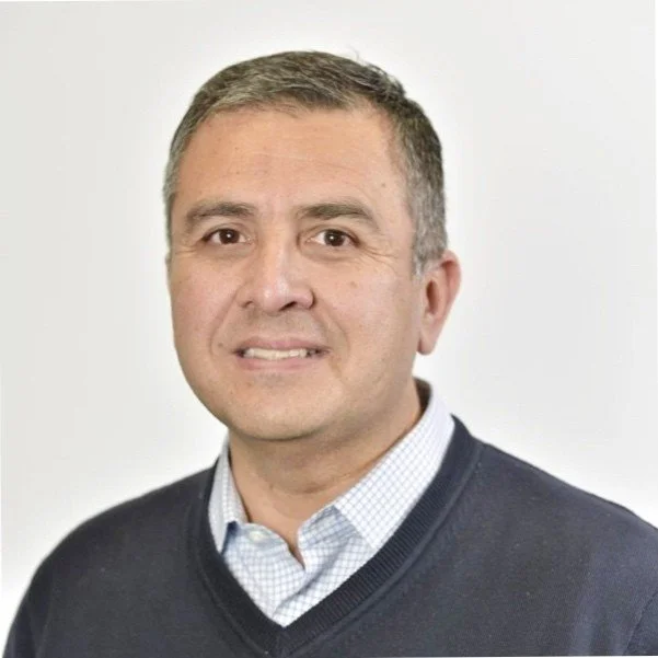 Smiling man in a sweater and collared shirt, white background